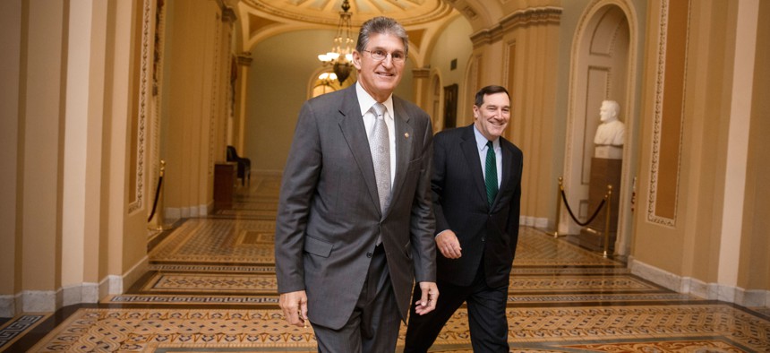 Sen. Joe Manchin, D-W.Va., left, walks with Sen. Joe Donnelly, D-Ind., at the Capitol in Washington, Jan. 26, 2015.