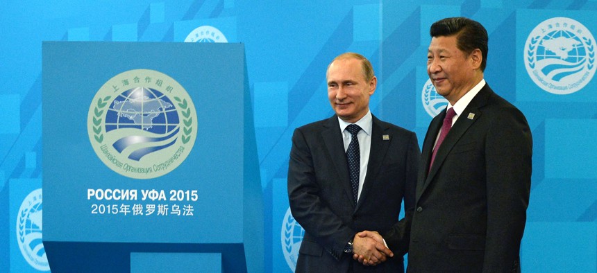 Russian President Vladimir Putin, left, shakes hands with Chinese President Xi Jinping ahead of the Shanghai Cooperation Organization (SCO) summit in Ufa, Russia, Friday, July 10, 2015.
