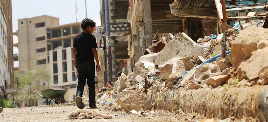 A boy walks near the rubbles of houses destroyed during fighting between tribal fighters and Shiite rebels known as Houthis in Taiz, Yemen, Sunday, Aug. 23, 2015.