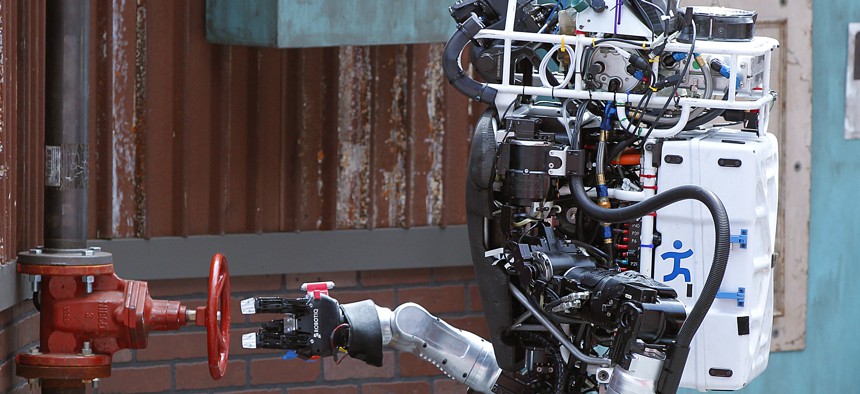 Robot Running Man from the Florida Institute for Human and Machine Cognition proceeds to turn a valve in the U.S. Defense Advanced Research Projects Agency Robotics Challenge in Pomona, Calif.