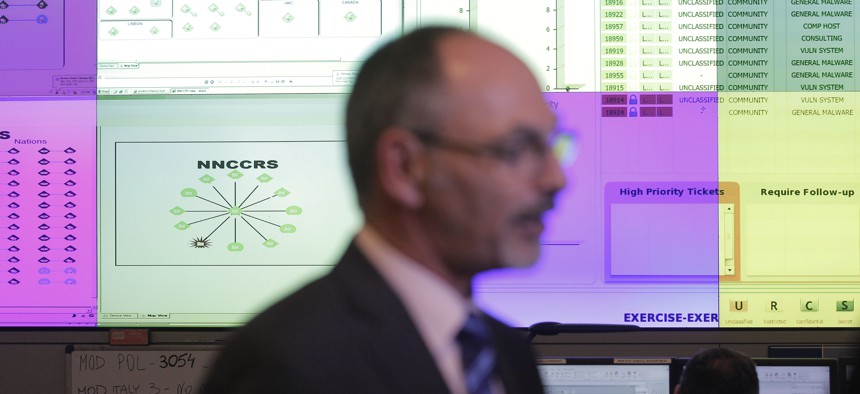 Director Ian West walks in front of computer screens at the NATO Computer Incident Response Capability technical center, at NATO's military headquarters. 