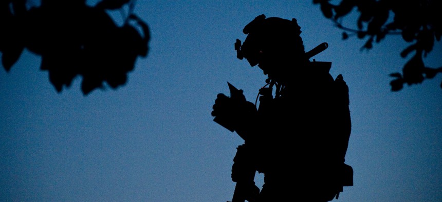 A U.S. Navy SEAL team member, with Special Operations Task Force – South, reviews a map of the objective area during the early morning hours of a village clearing operation in Shah Wali Kot District, June 25, 2011, Kandahar province, Afghanistan.