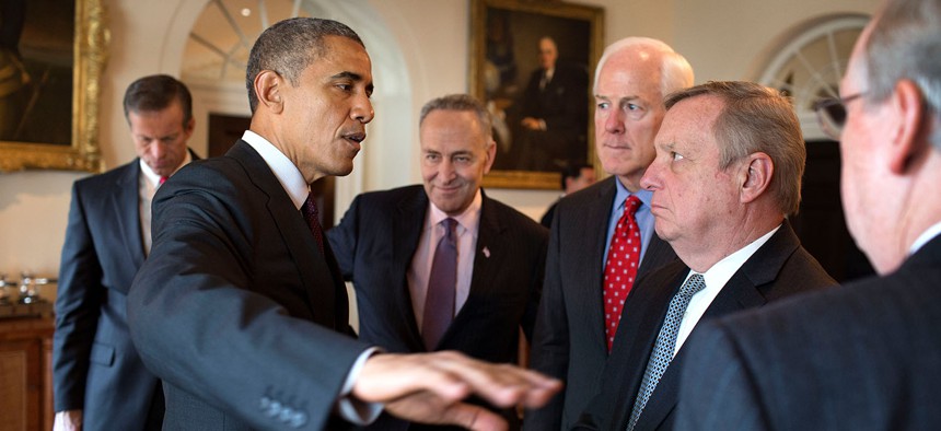 President Barack Obama speaks with a group of U.S. Senators following a meeting with the bipartisan, bicameral leadership of Congress in the Cabinet Room of the White House, Jan. 13, 2015. 
