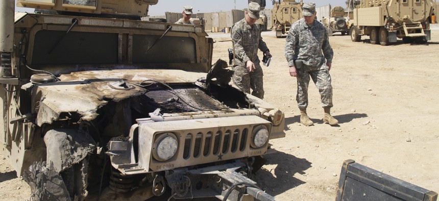 A humvee damaged by an EFP is looked over at the U.S. Army Patrol Base of the 2-28 Infantry in Al Hillah, 62 miles south of Baghdad.