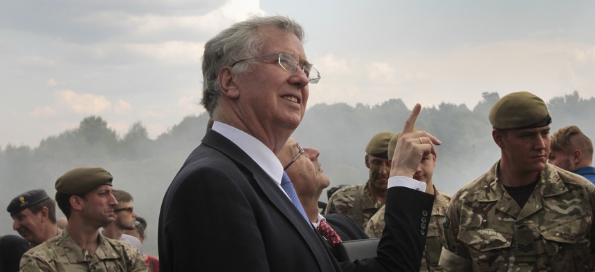 British Secretary of State for Defense, Michael Fallon, watches proceedings as British serviceman teach Ukrainian soldiers on the military base outside Zhitomir, Ukraine, Tuesday, Aug. 11, 2015.