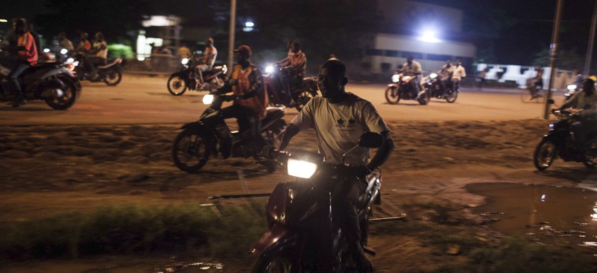 People on motor bikes used as taxi drive around following demonstrations near the presidential palace after soldiers arrested Burkina Faso’s transitional president and prime minister in Ouagadougou, Burkina Faso, Wednesday, Sept. 16, 2015. 