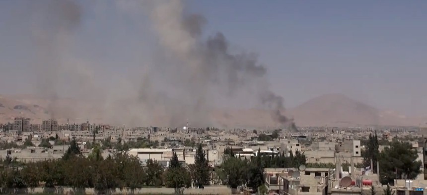 This image made from video posted online by the Shaam News Network, a loosely organized group opposed to Bashar Assad, on Sunday, Aug. 16, 2015, which has been verified and is consistent with other AP reporting, shows smoke rising over a Damascus suburb.