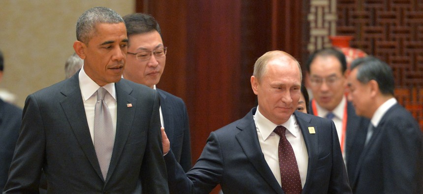 Russian President Vladimir Putin, right, passes by US President Barack Obama at the Asia-Pacific Economic Cooperation (APEC) Summit, Tuesday, Nov. 11, 2014 in Beijing.