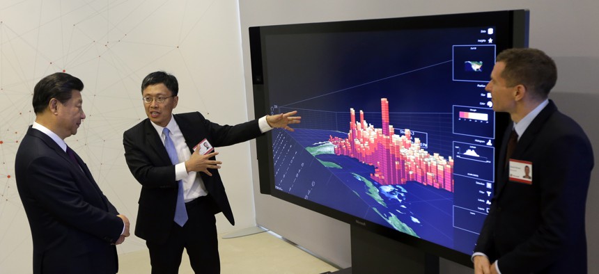 Chinese President Xi Jinping listens as Microsoft's Harry Shum demonstrate how Microsoft Surface technology can be used for data visualization.