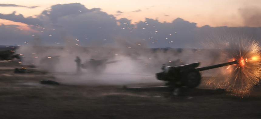 In this photo taken on Wednesday, Oct. 7, 2015, Syrian army howitzers fire near the village of Morek in Syria.