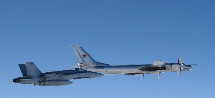 A CF-18 Hornet from 4 Wing Cold Lake flies next to a Russian Tu-95 Bear bomber on September 5. 