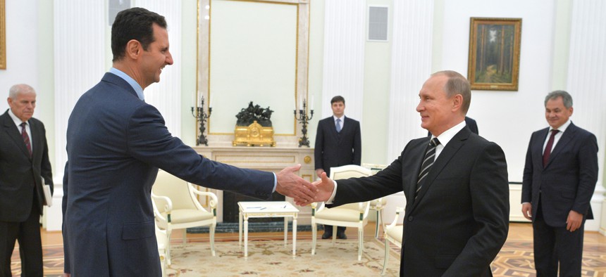 n this photo taken on Tuesday, Oct. 20, 2015, Russian President Vladimir Putin, right, shakes hand with Syrian President Bashar Assad in the Kremlin in Moscow, Russia.