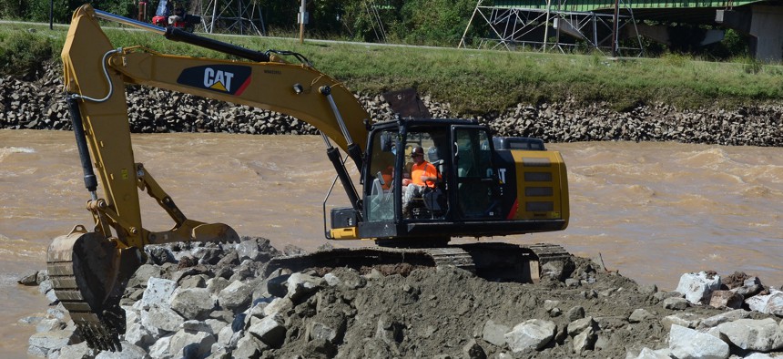 U.S. Soldiers from the South Carolina Army National Guard and civilian employees work together to prepare the Columbia Canal for the construction of a new dam during a statewide flood response, Oct. 6, 2015.