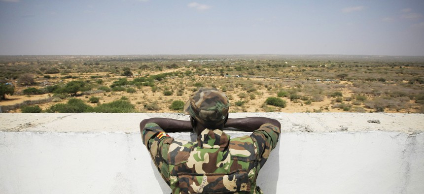 A Ugandan soldier serving with the African Union (A.U.) Mission in Somalia (AMISOM) looks over an open tract of land from the roof of Mogadishu University.