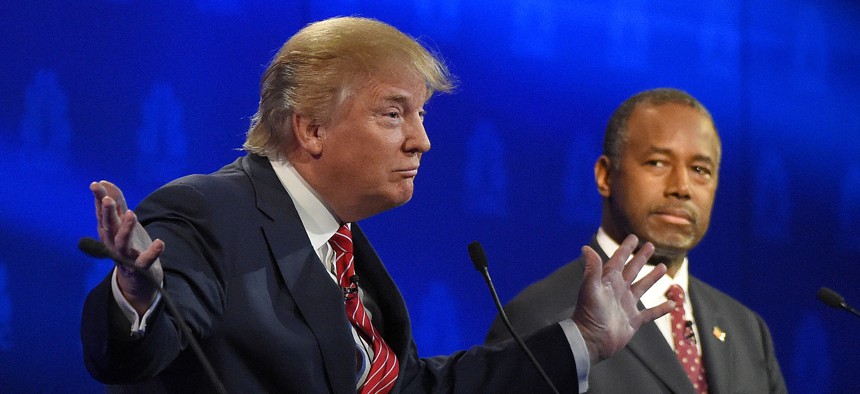 Ben Carson, right, watches as Donald Trump speaks during the CNBC Republican presidential debate at the University of Colorado, Wednesday, Oct. 28, 2015, in Boulder, Colo.
