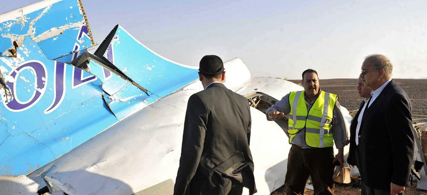 Egyptian Prime Minister Sherif Ismail, right, looks at the remains of a crashed Russian passenger jet in Hassana, Egypt.