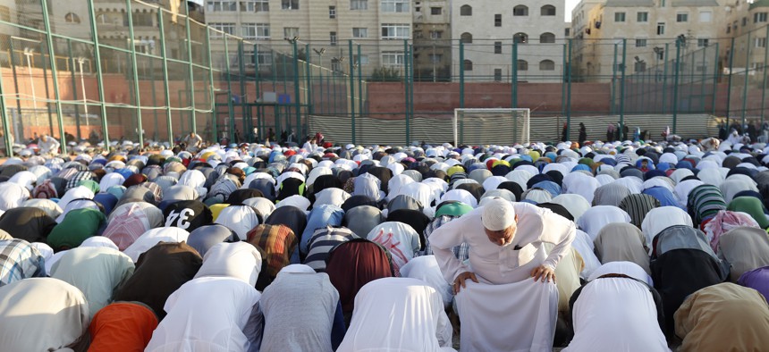 In this Friday, July 17, 2015 photo, worshippers attend the Eid al-Fitr prayers in an open field in Amman, Jordan. 