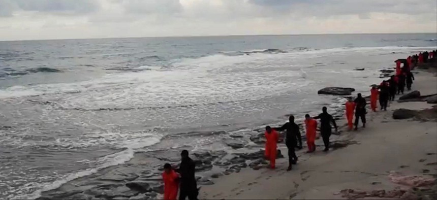 In this file image made from a video released Sunday, Feb. 15, 2015 by militants in Libya claiming loyalty to the Islamic State group purportedly shows Egyptian Coptic Christians in orange jumpsuits being led along a beach.
