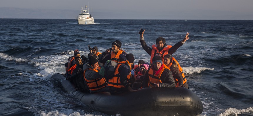 Refugees and migrants arrive safely on a dinghy from the Turkish coast to the northeastern Greek island of Lesbos on Tuesday, Nov. 17, 2015. 