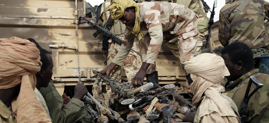 Chadian soldiers collect weapons seized from Boko Haram fighters in the Nigerian city of Damasak, Nigeria, Wednesday March 18, 2015.