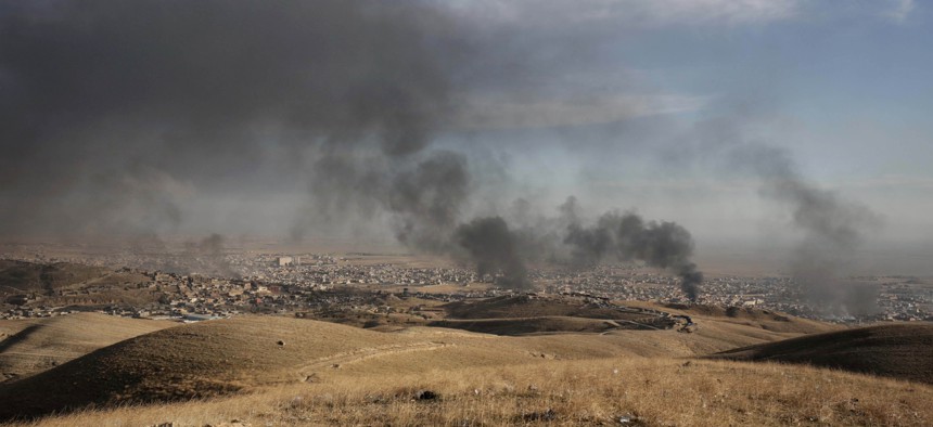 Smoke rises over Sinjar, northern Iraq from oil fires set by Islamic State militants as Kurdish Iraqi fighters, backed by U.S.-led airstrikes, launch a major assault on Thursday, Nov. 12, 2015.