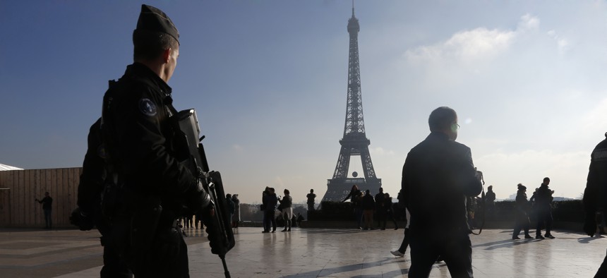 French police officers patrol near the Eiffel Tower, in Paris, Monday Nov. 23, 2015.