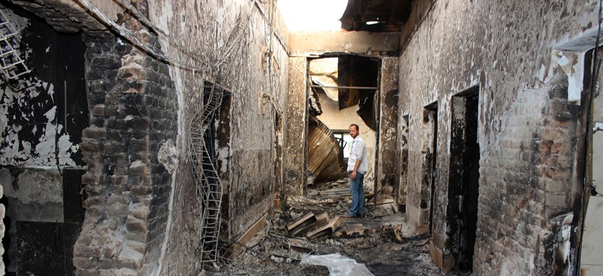 In this Oct. 16, 2015, file photo, an employee of Doctors Without Borders stands inside the charred remains of their hospital after it was hit by a U.S. airstrike in Kunduz, Afghanistan.