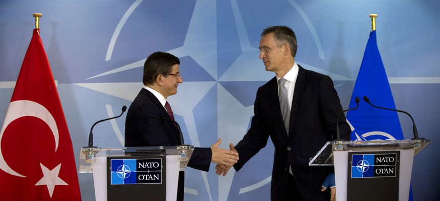 Turkish Prime Minister Ahmet Davutoglu, left, shakes hands with NATO Secretary General Jens Stoltenberg after addressing a media conference at NATO headquarters in Brussels on Monday, Nov. 30, 2015.