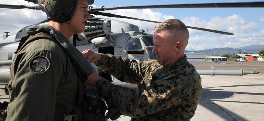 Brig. Gen. Eric M. Smith pins a Navy Achievement Medal on Sgt. Steven A. Meyer, a CH-53 Super Stallion crew member with Special Purpose Marine Air-Ground Task Force-Southern Command.