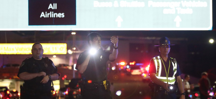 Officers stand at the entrance to New Orleans International Airport, Friday, March 20, 2015, in Kenner, La.
