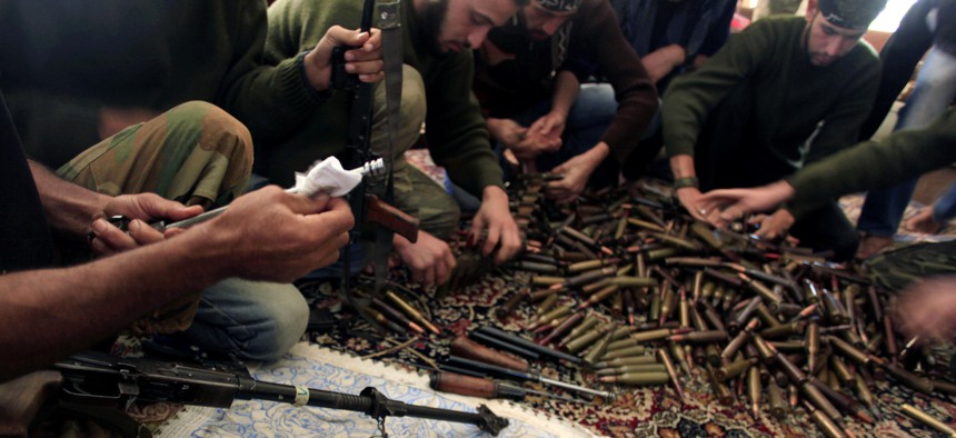 In this Wednesday, Nov. 14, 2012 file photo, Free Syrian Army fighters clean their weapons and check ammunition at their base on the outskirts of Aleppo, Syria.