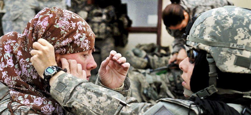 U.S. Army Maj. Rosemary Reed of the Khowst Provincial Reconstruction Team helps U.S. Army Sgt. 1st Class Paula Reill of the 3-19th Indiana Agricultural Development Team with her head scarf.