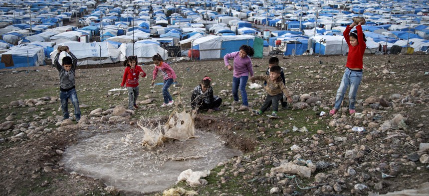 In this Saturday, Nov. 28, 2015 photo, Syrian refugee children play at a temporary refugee camp in Irbil, northern Iraq.