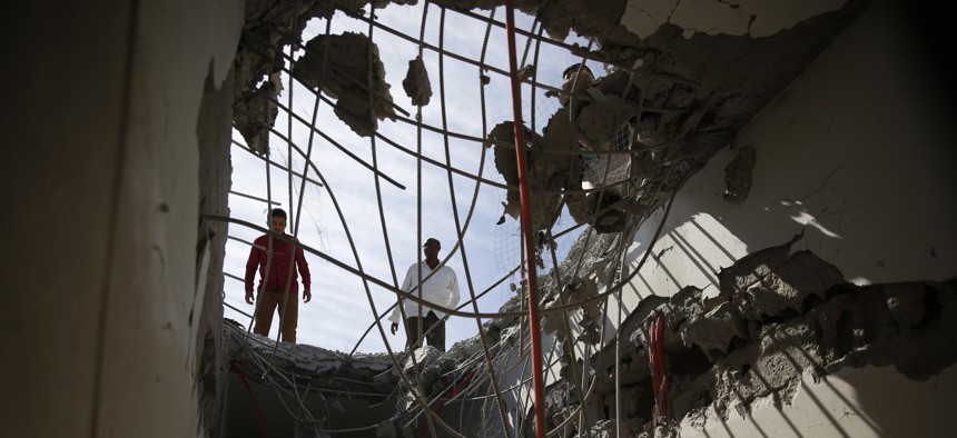 Men inspect a building damaged by a Saudi-led airstrike in Sanaa, Yemen, Tuesday, Jan. 5, 2016.