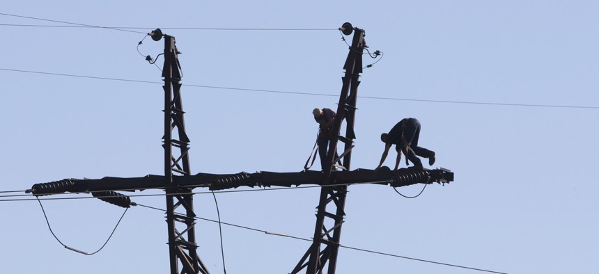 Workers repair an electricity power line damaged during shelling near a power station outside the city of Slovyansk, Donetsk Region, eastern Ukraine Thursday, July 10, 2014.