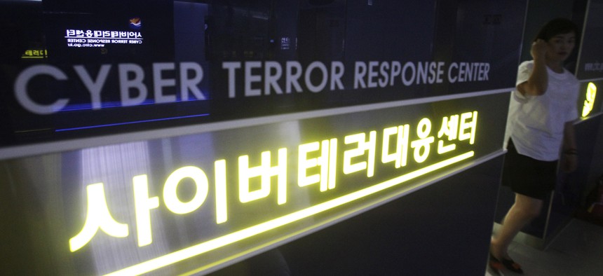 In this July 16, 2013 file photo, a woman walks by a sign at Cyber Terror Response Center of National Police Agency in Seoul, South Korea. 