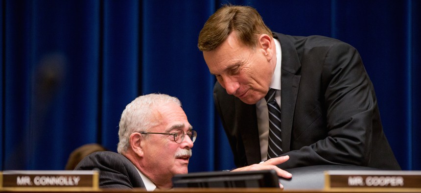 Rep. Gerald Connolly, D-Va., left, speaks with Rep. John Mica, R-Fla., right, on Capitol Hill in Washington, Wednesday, June 17, 2015, during the House Oversight and Government Reform Committee hearing.