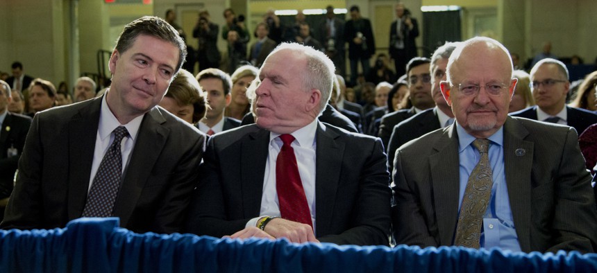 From left, FBI Director James Comey, CIA Director John Brennan, and Director of National Intelligence James Clapper sit together in the front row before President Barack Obama spoke about National Security Agency (NSA) surveillance, Friday, Jan. 17, 2014,