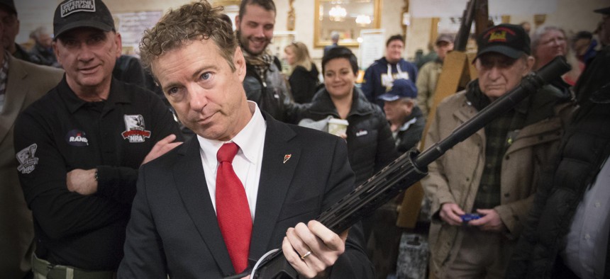 Republican presidential candidate, Sen. Rand Paul, R-Ky. handles a AR-15 style rifle as he meets with customers during a campaign stop at a gun show at Bektash Shrine Center, Saturday, Jan. 23, 2016, in Concord.