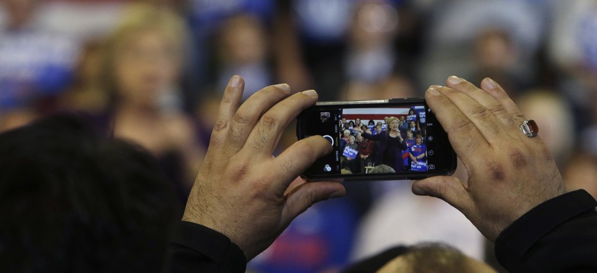 A potential voter takes a photo as Democratic presidential candidate Hillary Clinton speaks at a campaign event, Tuesday, Feb. 2, 2016, in Nashua, N.H. 