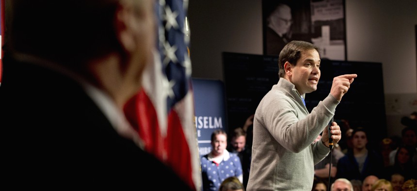 Security stands at left as Republican presidential candidate, Sen. Marco Rubio, R-Fla. speaks during a town hall meeting at the Saint Anselm Institute of Politics in Manchester, N.H., Thursday Feb. 4, 2016.