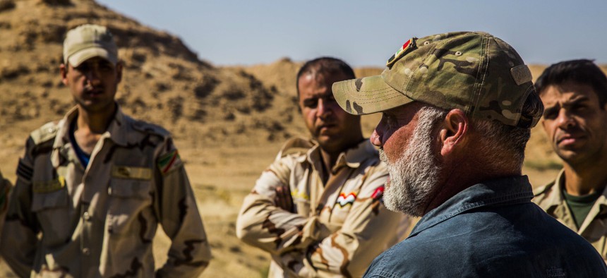 Iraqi Soldiers listen to a civilian contractor attached to Task Force Al Asad, talk about counter-improvised explosive device aboard Al Asad Air Base, Iraq, April 2, 2015.