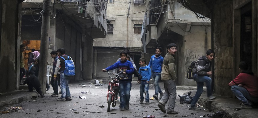 In this Thursday, Feb. 11, 2016 photo, school boys play in a street in Aleppo, Syria. 