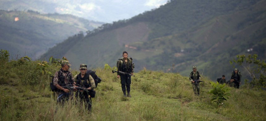 In this Jan. 3, 2016 photo, members of the 36th Front of the Revolutionary Armed Forces of Colombia or FARC, trek to a new camp in Antioquia state, in the northwest Andes of Colombia.