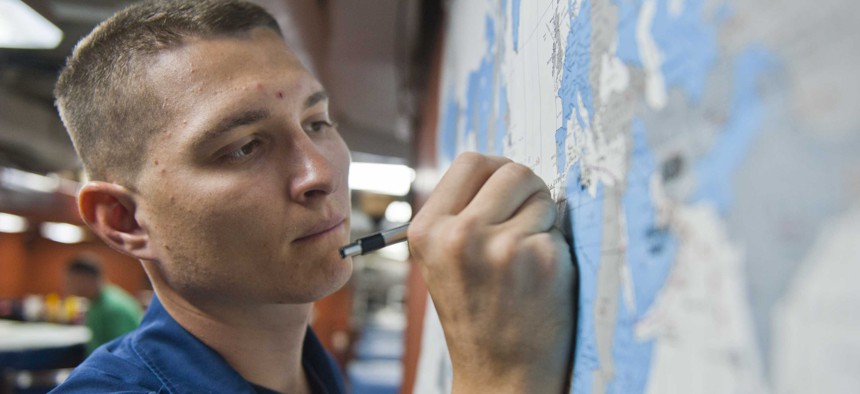 A U.S. sailor reviews a map aboard the Ticonderoga-class guided-missile cruiser USS Cape St. George (CG 71), July 28, 2012.