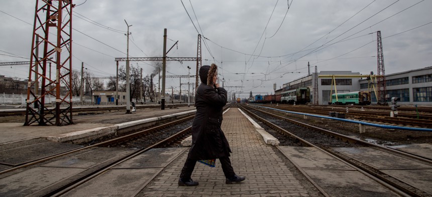 In this photo taken on Friday, Feb. 5, 2016, a local woman walks along a rail-road crossing in Debaltseve, eastern Ukraine. Money from Russia helps to rebuild the eastern Ukrainian town of Debaltseve, a strategic rail hub that rebels pounded  recently.