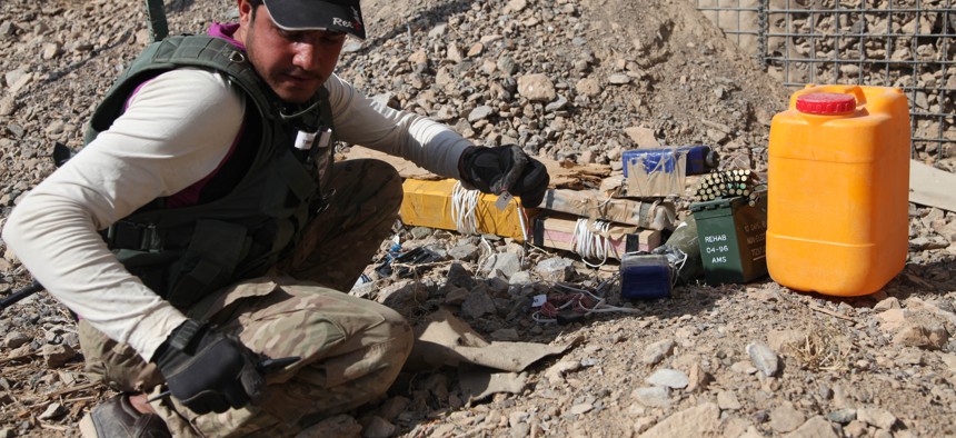 An Afghan Civilian Mine Removal Group (CMRG) member investigates IEDs during a training simulation in Panjwai district, Kandahar province, Afghanistan, Nov. 19, 2013. 
