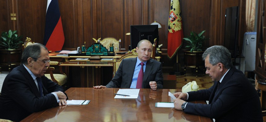 Russian President Vladimir Putin, center, Foreign Minister Sergey Lavrov, left, and Defense Minister Sergey Shoygu, right, meet in the Kremlin in Moscow, Mon., March 14, 2016. 