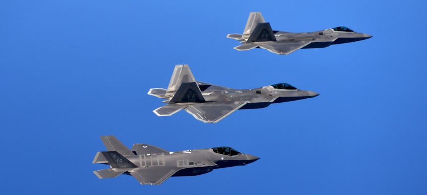 F-22 Raptors from the 94th Fighter Squadron and F-35A Lightning IIs fly in formation after completing a training mission.