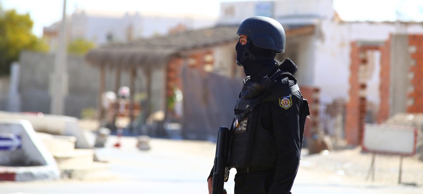 Tunisian police officers take positions as they search for attackers still at large in the outskirts of Ben Guerdane, southern Tunisia, Tuesday, Match 8, 2016.